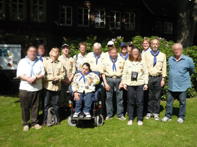 Gruppenbild von der Pfingstfahrt in 2002 nach Nottuln: 15 Pfadfinderinnen und Pfadfinder in einer beige-farbenen Pfadfinderkluft und mit einem blauen Halstuch. Eine der Teilnehmenden nutzt einen Rollstuhl.